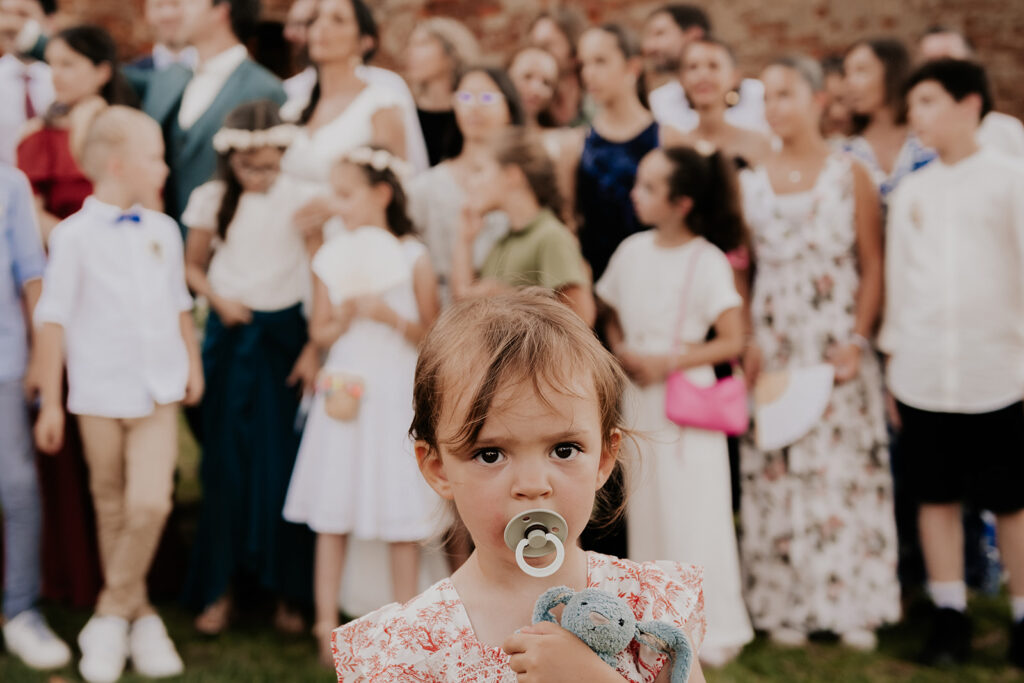 Photographe mariage Toulouse - photo de groupe - petite fille au premier plan avec sa tétine dans la bouche