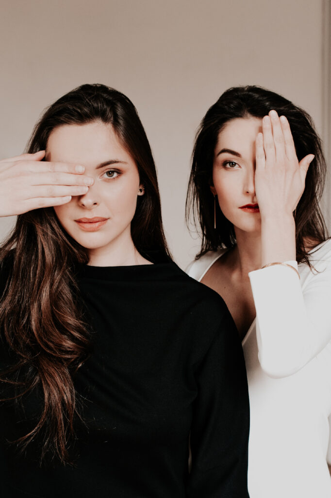 Portrait mode de deux femmes posant pour la photographe Céline Deligey, shooting pour la créatrice Delphine Josse, une main sur l’œil, dans une mise en scène élégante et graphique.