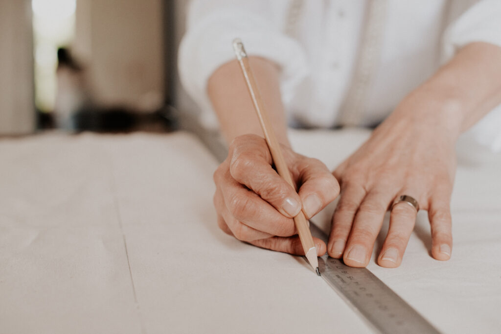 Gros plan main traçant des mesures sur tissu, photo artisanat couture