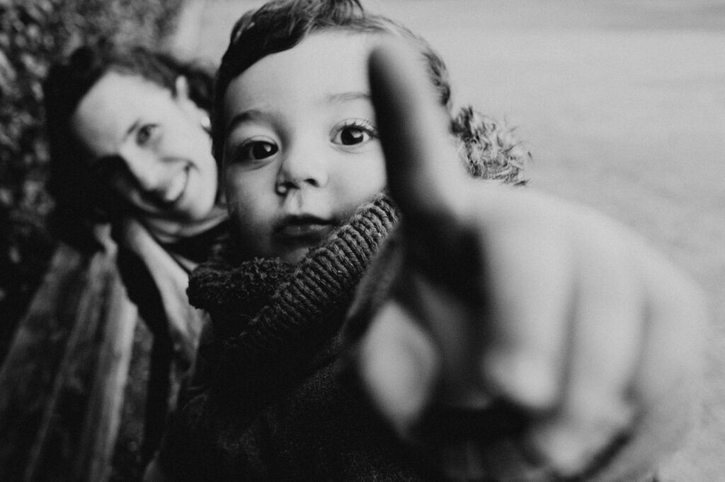 un enfant essaye de toucher l'appareil photo de la photographe de famille céline deligey