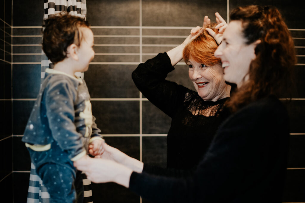 photographe famille toulouse , reportage photo où l on voit une mamie faire le clown devant son petit fils
