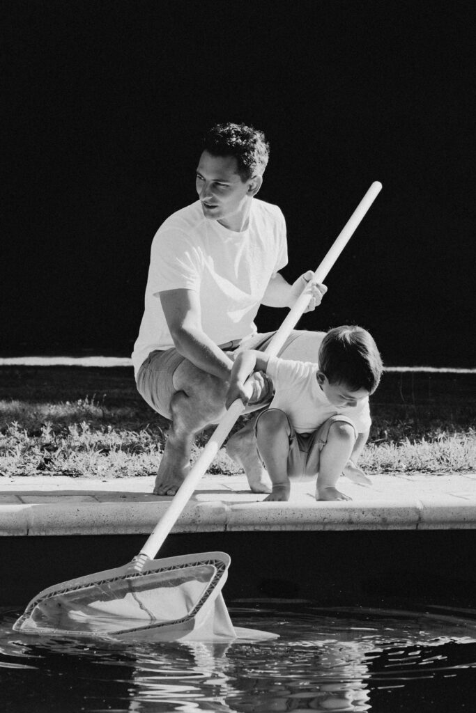 un pere et son fils au bord de la piscine