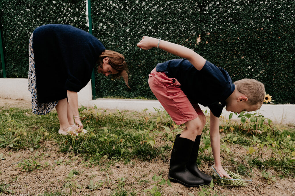 une scène rigolote capturée par Céline Deligey, photographe de familles à Toulouse: une maman et son fils récoltent des légumes dans la meme position