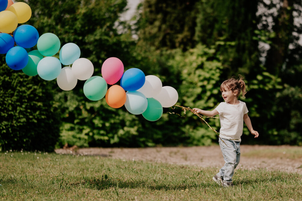 une petite fille transporte des ballons en l'aire