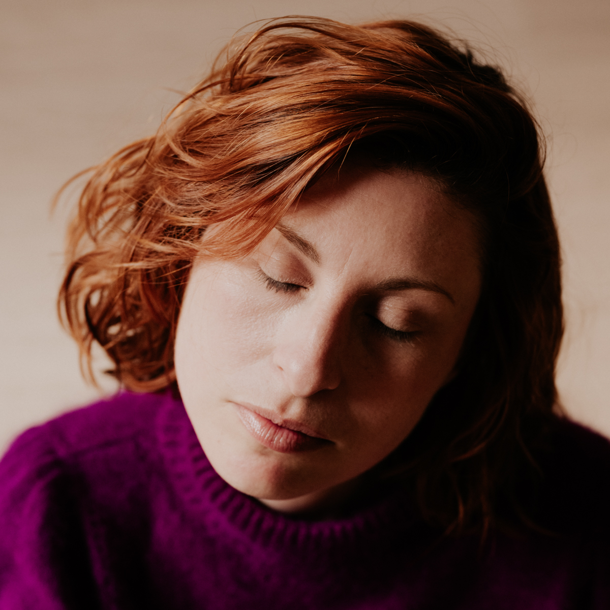 portrait professeur de yoga au pull violet. elle a les yeux fermés. photographiée à toulouse