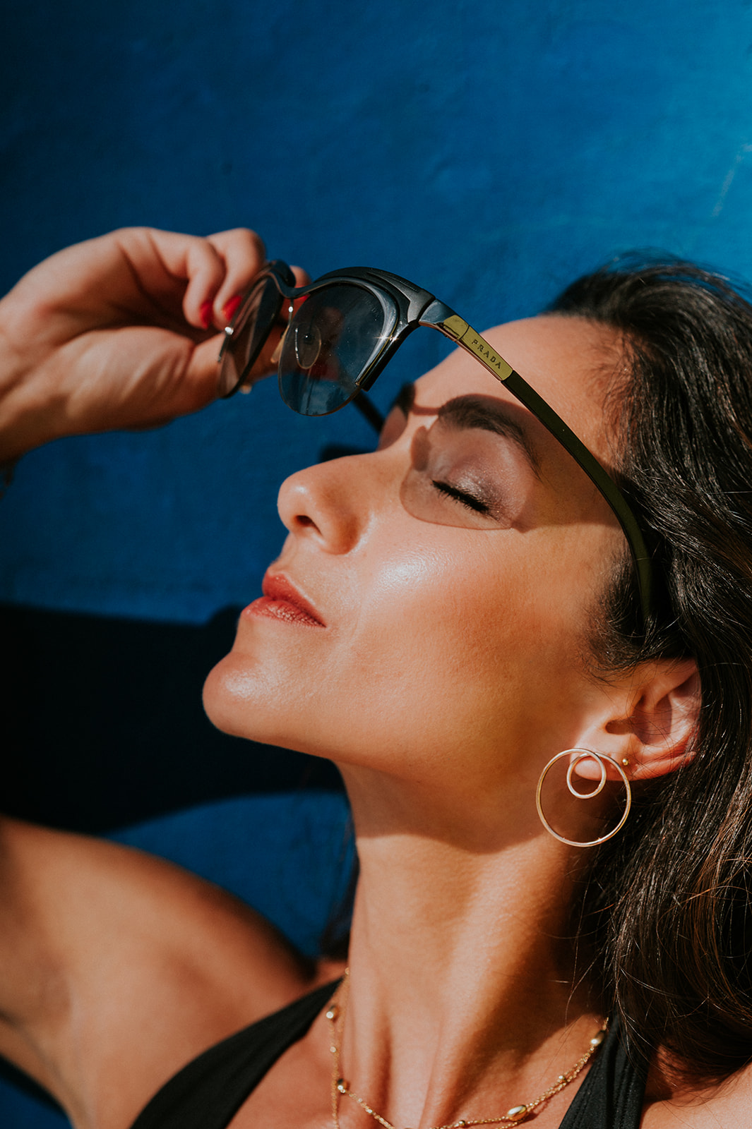 portrait de femme qui pose avec ses lunettes de soleil. Photographiée à toulouse par Céline Deligey