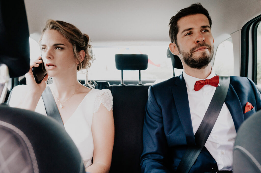 reportage photo de mariage toulouse. les mariés sont dans la voiture, on sent le stress. mariée au téléphone.