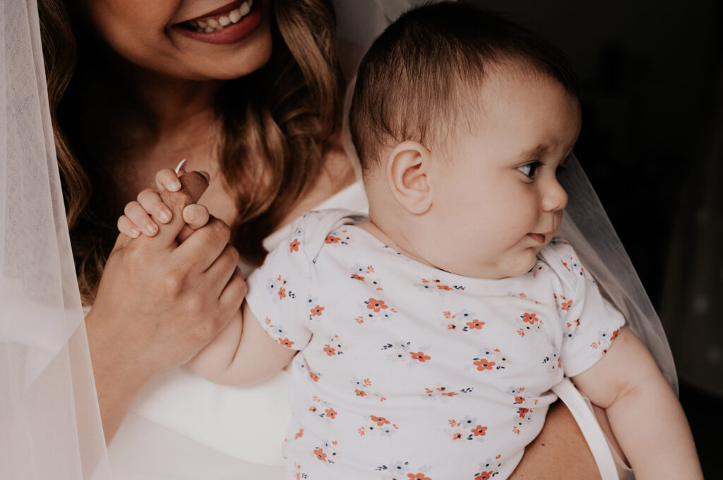 mariée portant son enfant dans les bras capturé par la photographe de mariage à Toulouse Céline Deligey