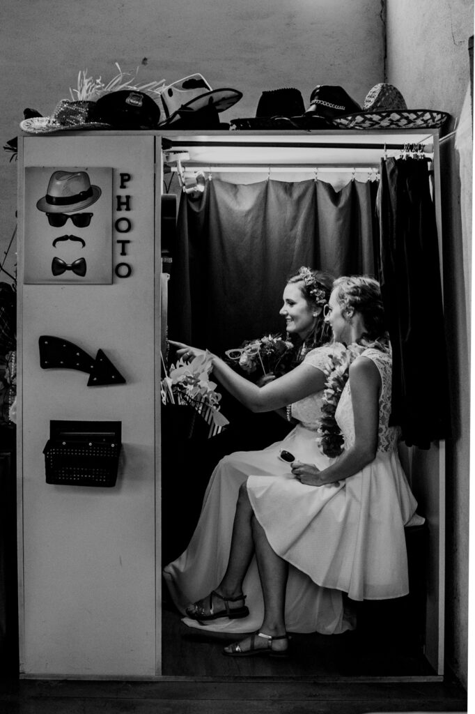 photographe mariage toulouse - la mariée et une amie dans un photobooth en noir et blanc