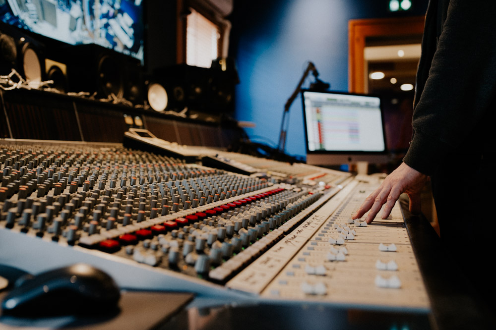 table de mixage avec les mains de l'ingé son entrain de travailler