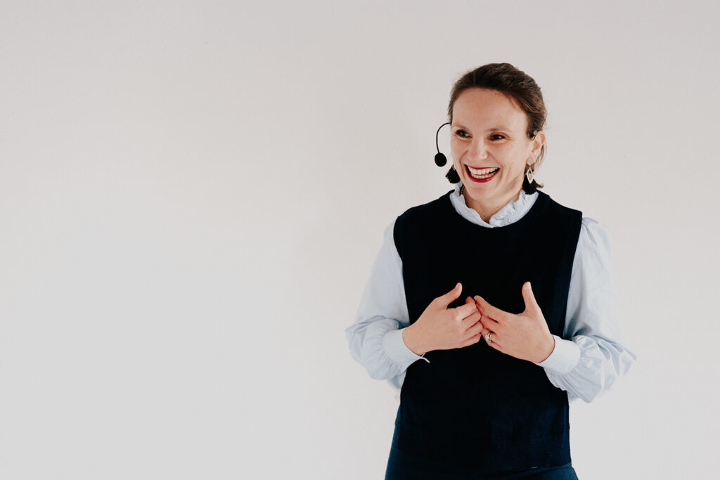 Portrait conférencière en formation avec micro-casque, sourire et gestuelle