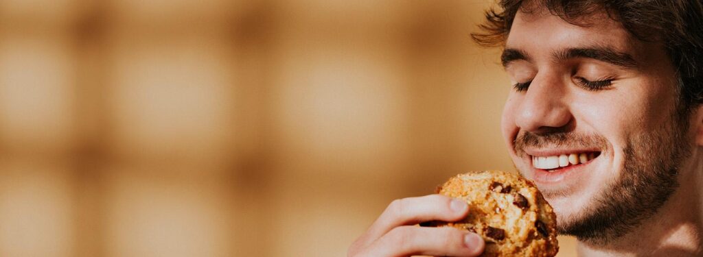 Portrait gourmand d’un homme savourant un cookie maison